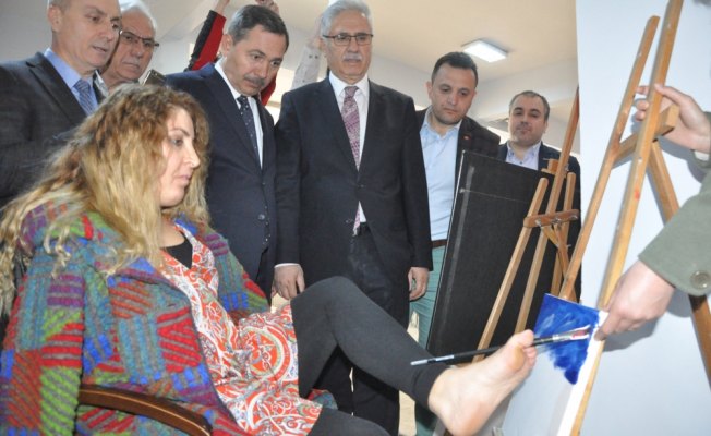 Ayaklarıyla resim çizdi, kitabını imzaladı