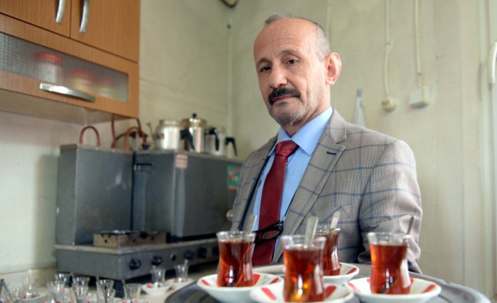 Takım elbiseyle çay servisi yapıyor