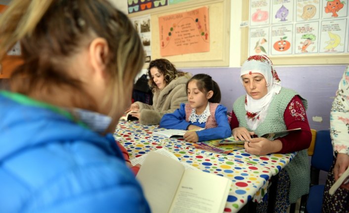 Köylüler sınıfta çocuklarıyla kitap okuyor