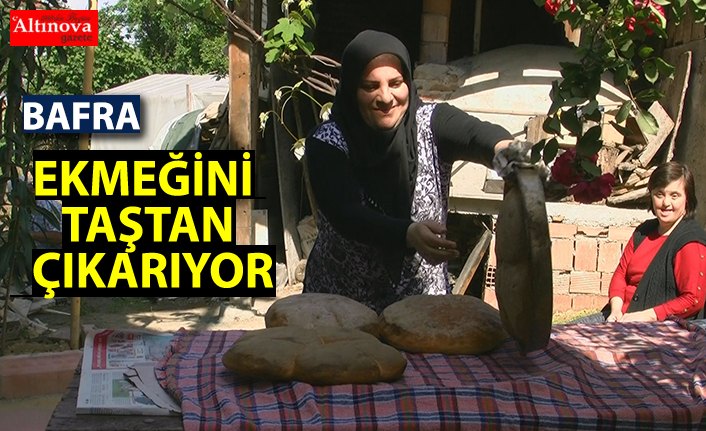 Elinin hamuruyla ekmeğini "taş fırın"dan çıkarıyor