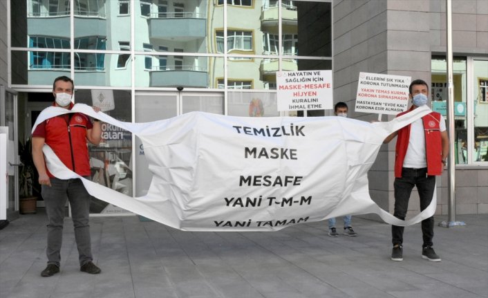 Gümüşhane'de gençler, maske şeklindeki pankartla Kovid-19 tedbirlerine dikkati çekti