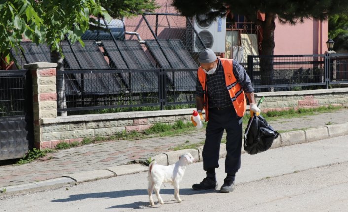 Peşinden ayrılmayan oğlağıyla cadde ve sokakları temizliyor