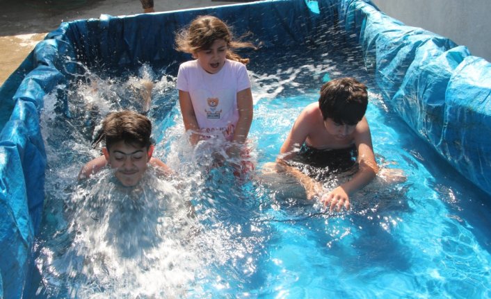 Amasya'da köy çocukları traktör römorkunu havuza çevirdi