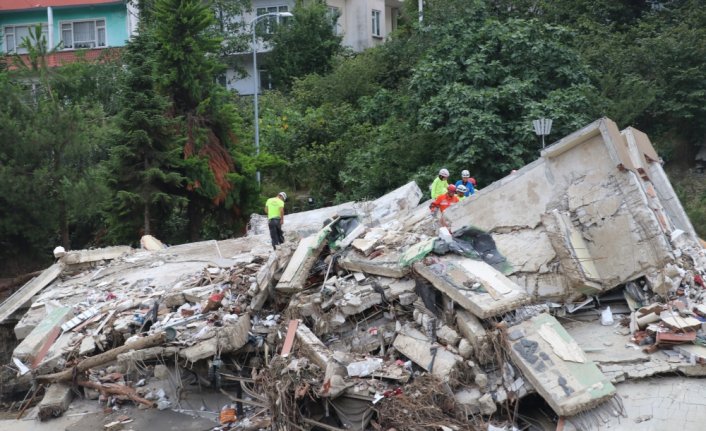 Sel nedeniyle yıkılan binanın altından yakınlarının sağ çıkmasını bekliyorlar