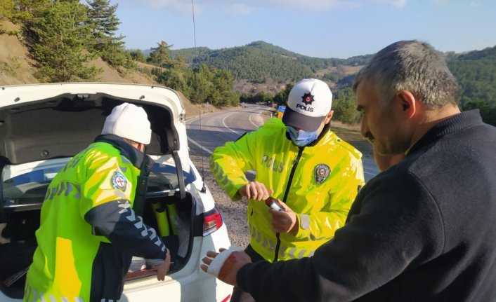 Polis devrilen tırdan çıkardığı sürücünün yaralanan elini sardı