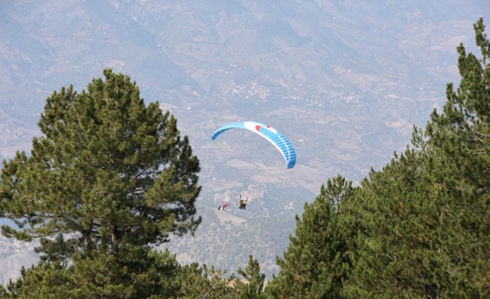 Yamaç paraşütünden açtığı afişle ambulanslara yol istiyor