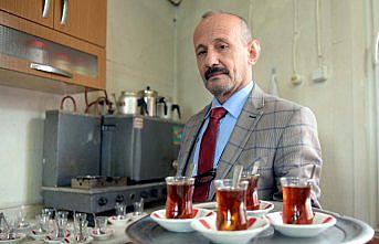 Takım elbiseyle çay servisi yapıyor