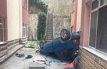 Site bahçesine devrilen otomobilin sürücüsü yaralandı
