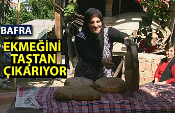 Elinin hamuruyla ekmeğini "taş fırın"dan çıkarıyor