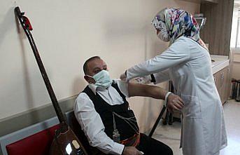 Bayburt'ta sazıyla aşı vurulmaya giden halk ozanı sağlık çalışanlarına moral verdi