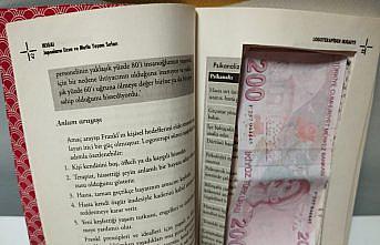 Samsun'da sahte parayı saklamak amacıyla kitabın içini para ölçüsünde kesen 2 zanlı yakalandı