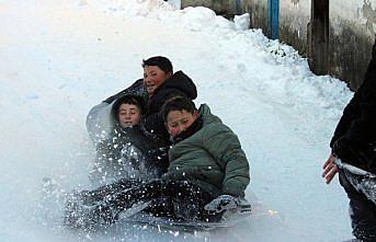 Mahalle yolunu kızak pistine çeviren çocuklar karın tadını çıkardı