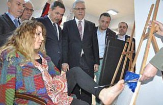 Ayaklarıyla resim çizdi, kitabını imzaladı