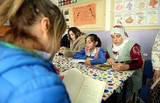 Köylüler sınıfta çocuklarıyla kitap okuyor